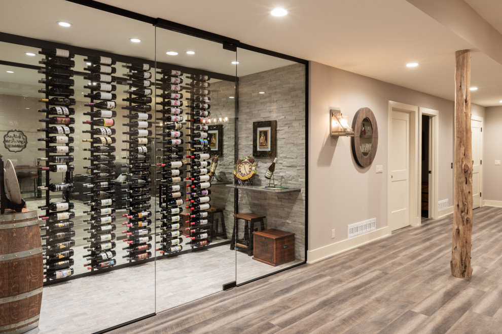 Photo of a medium sized rustic wine cellar in Omaha with display racks and grey floors.