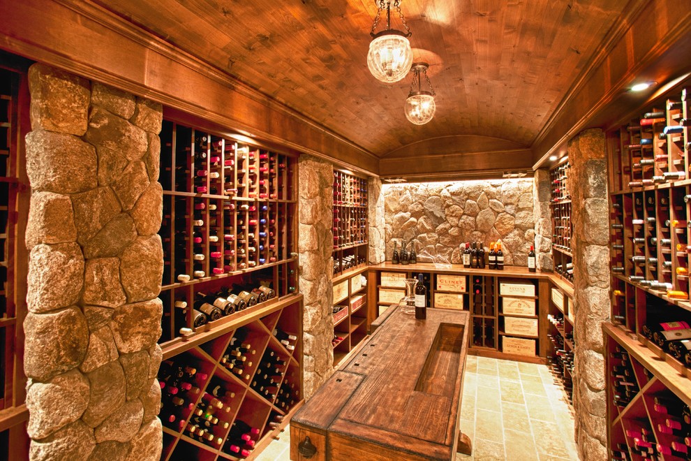Exempel på en klassisk vinkällare, med travertin golv och vinställ med diagonal vinförvaring