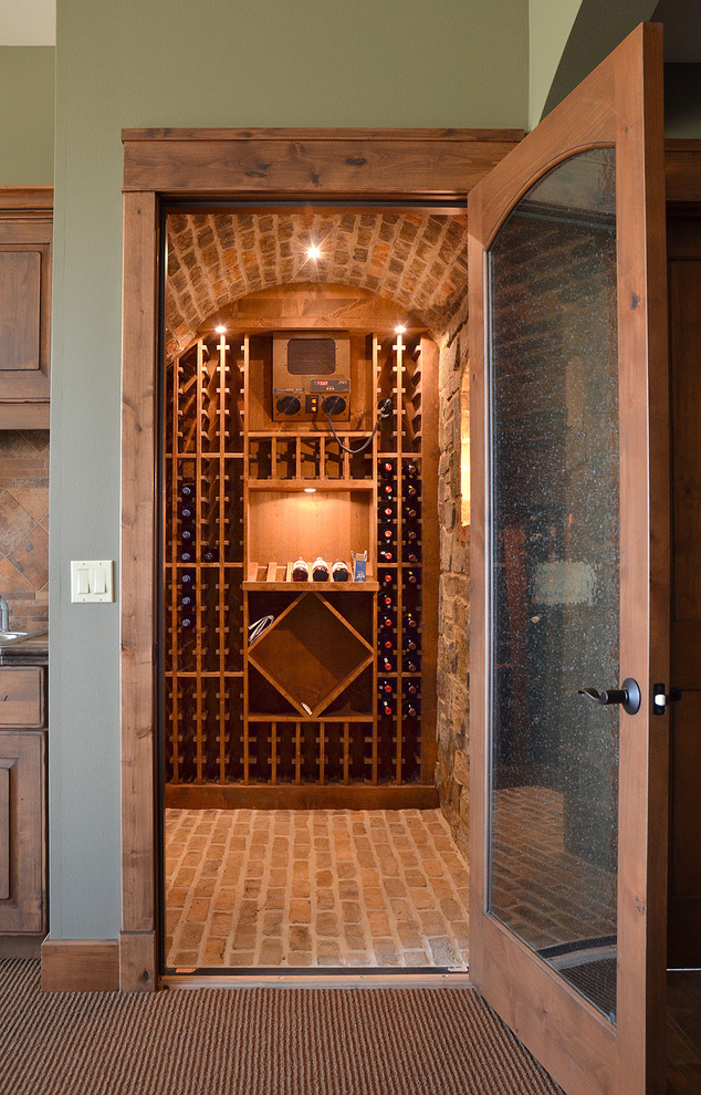 Réalisation d'une petite cave à vin avec un sol en brique et des casiers.