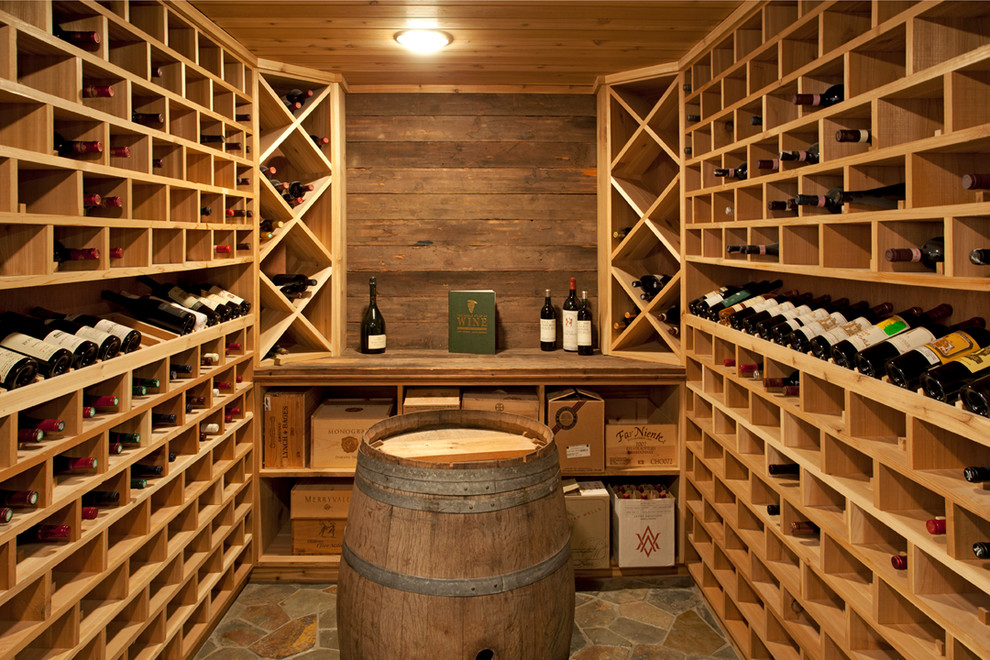 Wine cellar - mid-sized rustic travertine floor wine cellar idea in Minneapolis with display racks