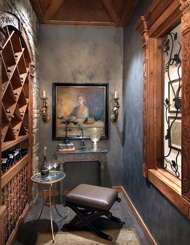 Foto på en mellanstor rustik vinkällare, med vinställ med diagonal vinförvaring, klinkergolv i keramik och grått golv