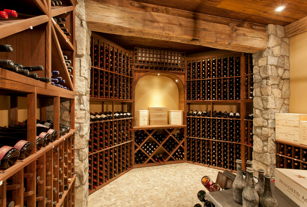 Idée de décoration pour une cave à vin chalet de taille moyenne avec un sol en bois brun et des casiers.