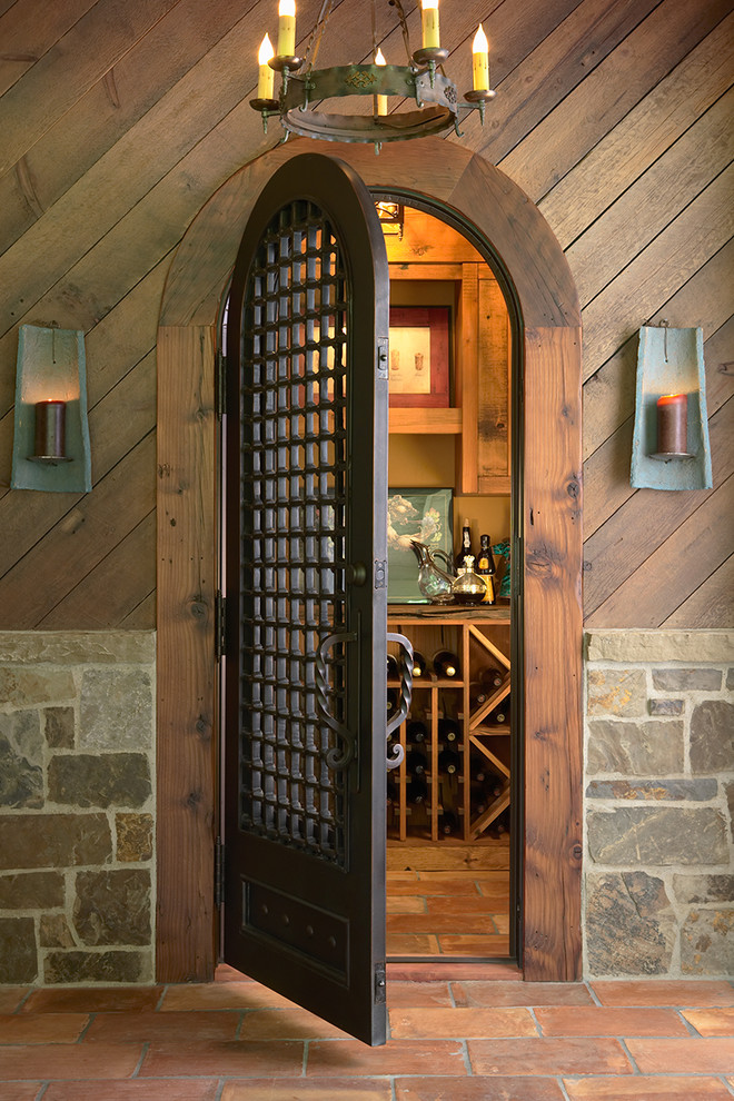 This is an example of a rustic wine cellar in Minneapolis with terracotta flooring and storage racks.