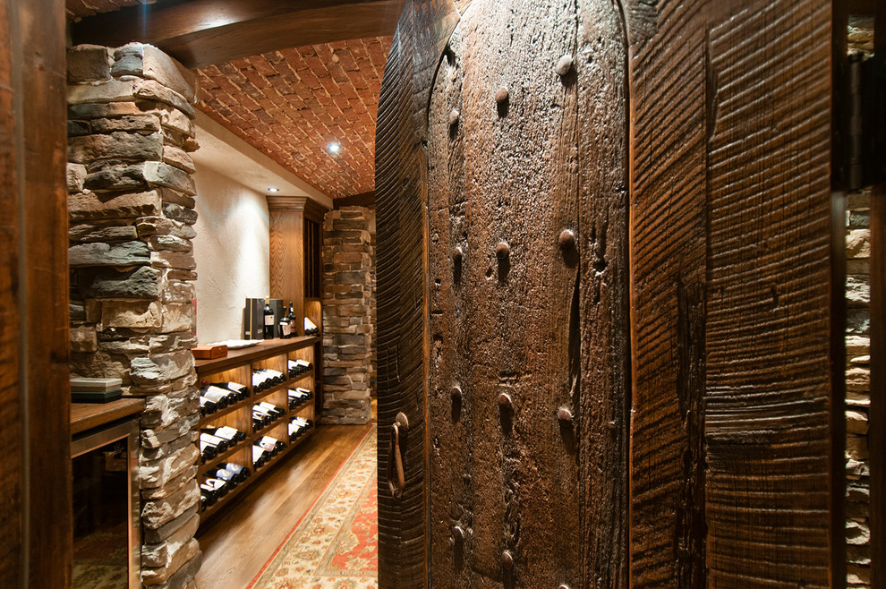 Mid-sized mountain style dark wood floor wine cellar photo in Raleigh with storage racks