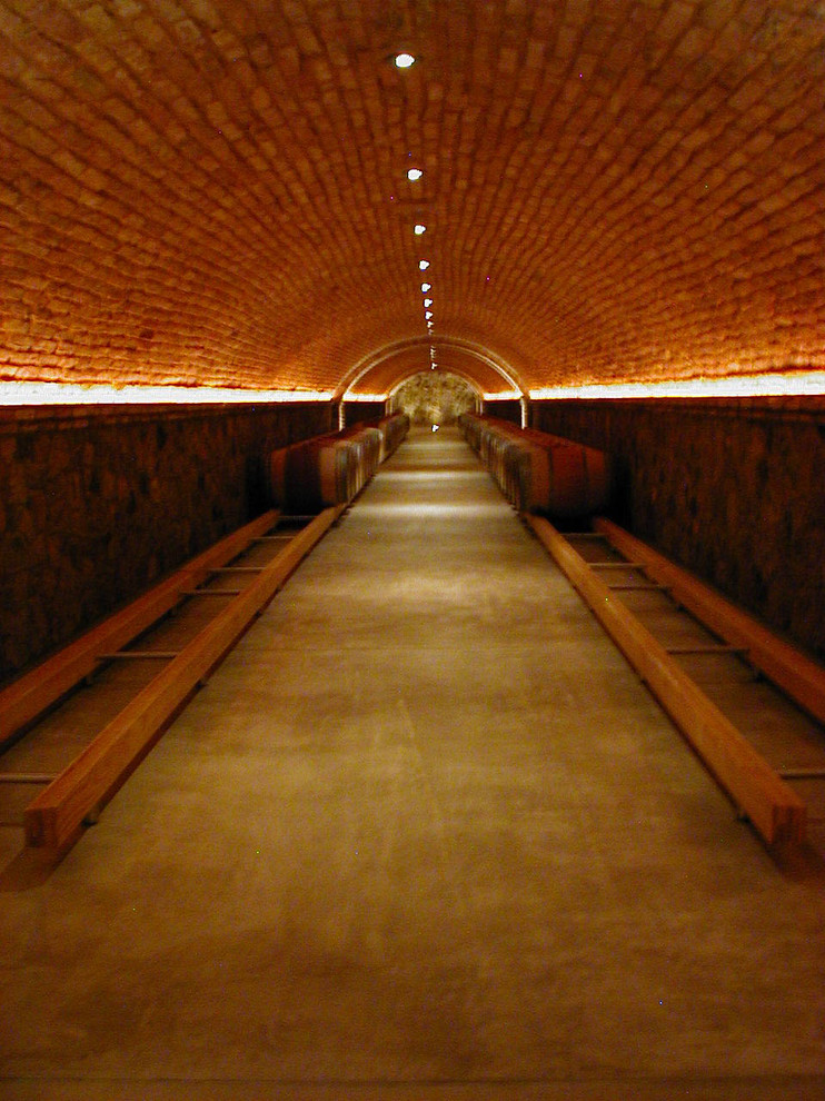 Klassisk inredning av en mycket stor vinkällare, med betonggolv och grått golv