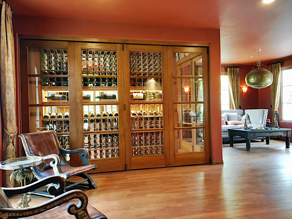 Inspiration for a large mediterranean dark wood floor and brown floor wine cellar remodel in Orange County with storage racks