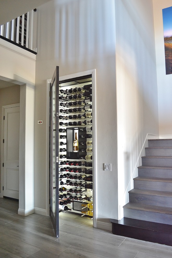 Wine cellar - small modern dark wood floor and gray floor wine cellar idea in San Diego with storage racks
