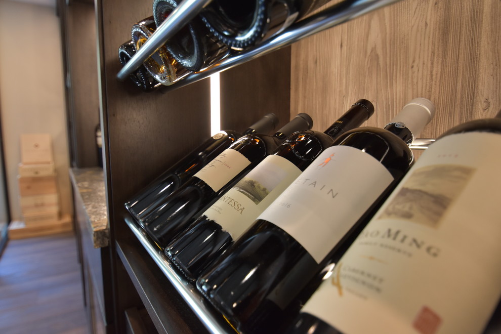 Wine cellar - large contemporary medium tone wood floor and brown floor wine cellar idea in Orange County with display racks