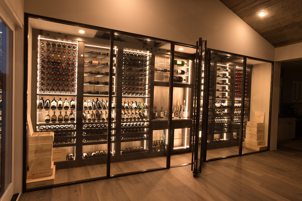 Inspiration for a large contemporary wine cellar in Orange County with medium hardwood flooring, display racks and brown floors.