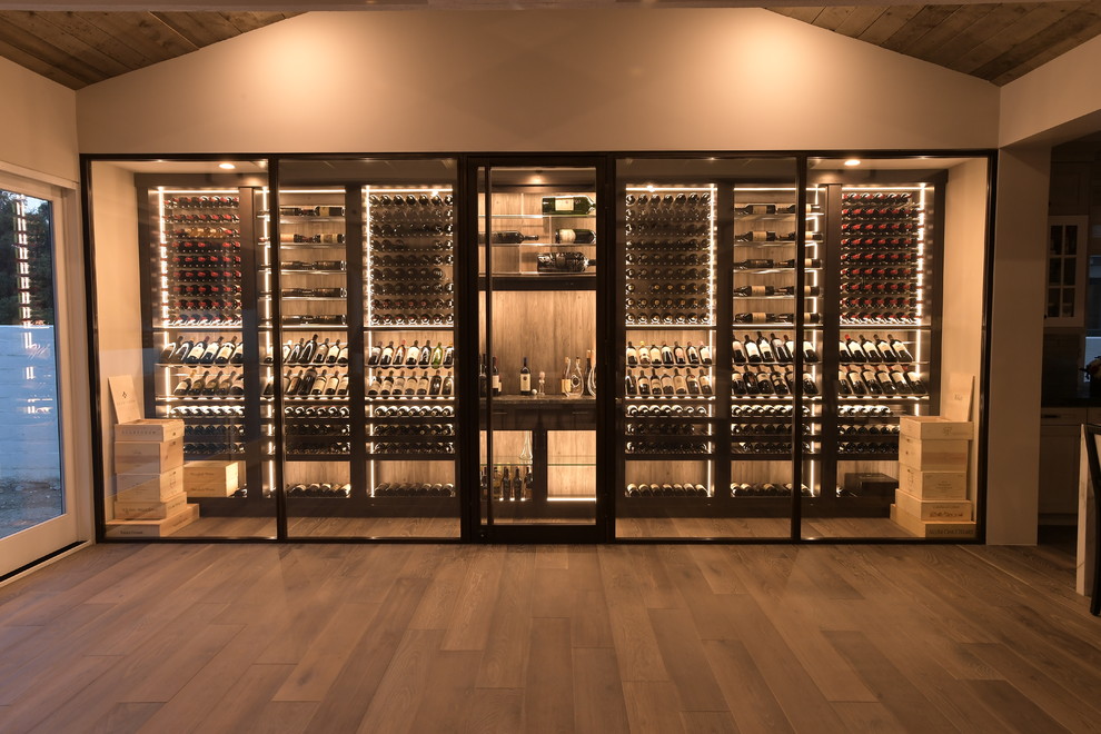 Großer Moderner Weinkeller mit braunem Holzboden, waagerechter Lagerung und braunem Boden in Orange County