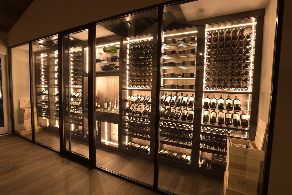 Photo of a large contemporary wine cellar in Orange County with medium hardwood flooring, display racks and brown floors.