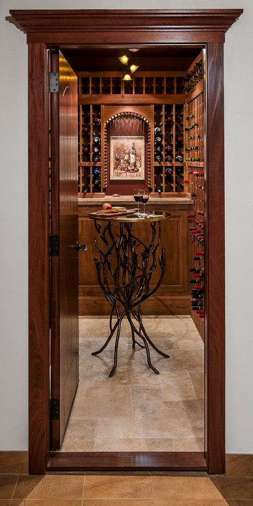 Cette image montre une cave à vin traditionnelle de taille moyenne avec un sol en travertin et des casiers.