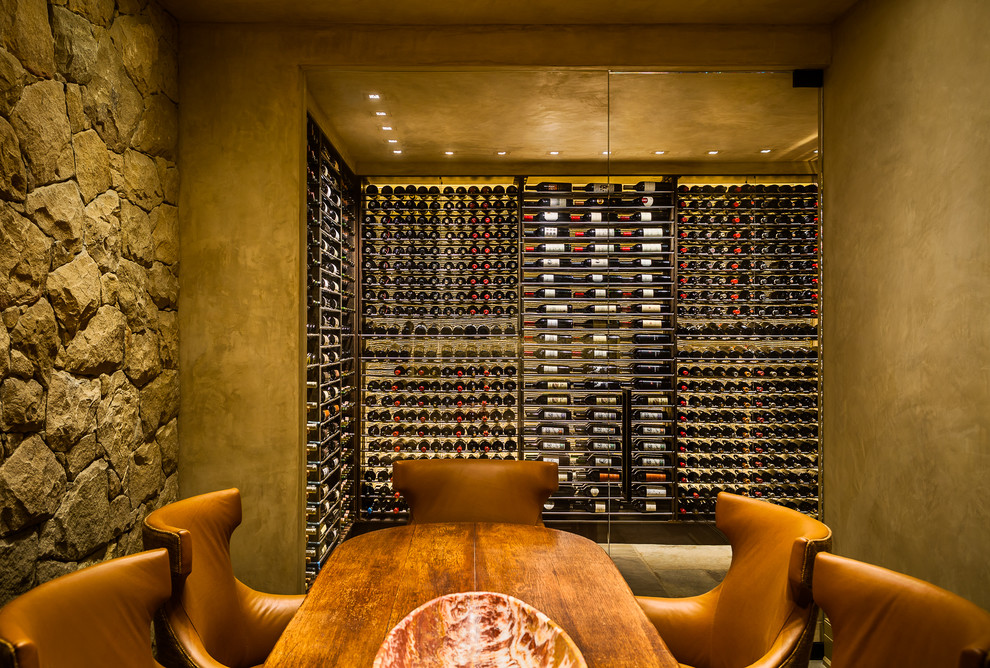 This is an example of a large rustic wine cellar in Santa Barbara with storage racks.