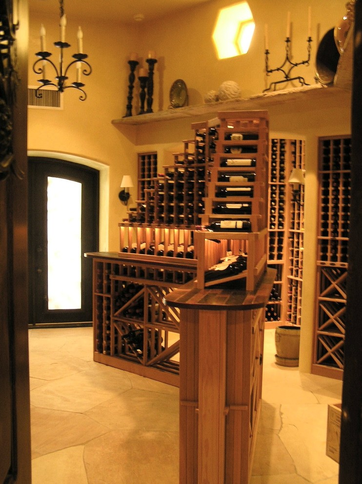 Photo of an expansive mediterranean wine cellar in Albuquerque with limestone flooring, storage racks and beige floors.