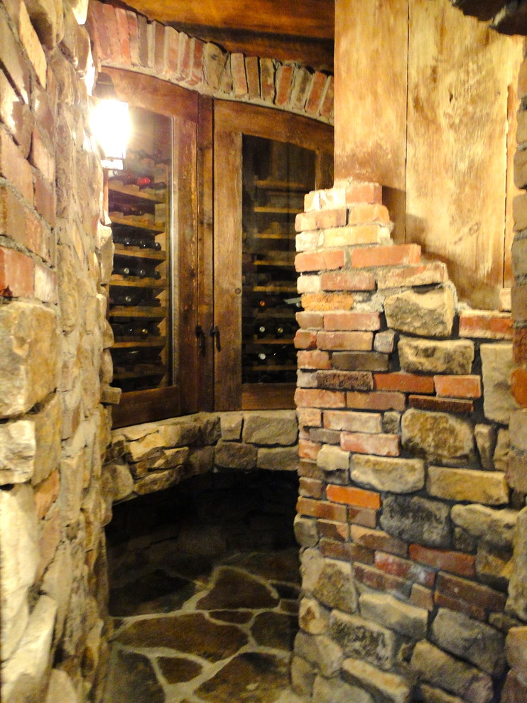 Réalisation d'une cave à vin craftsman avec un sol en ardoise et des casiers.