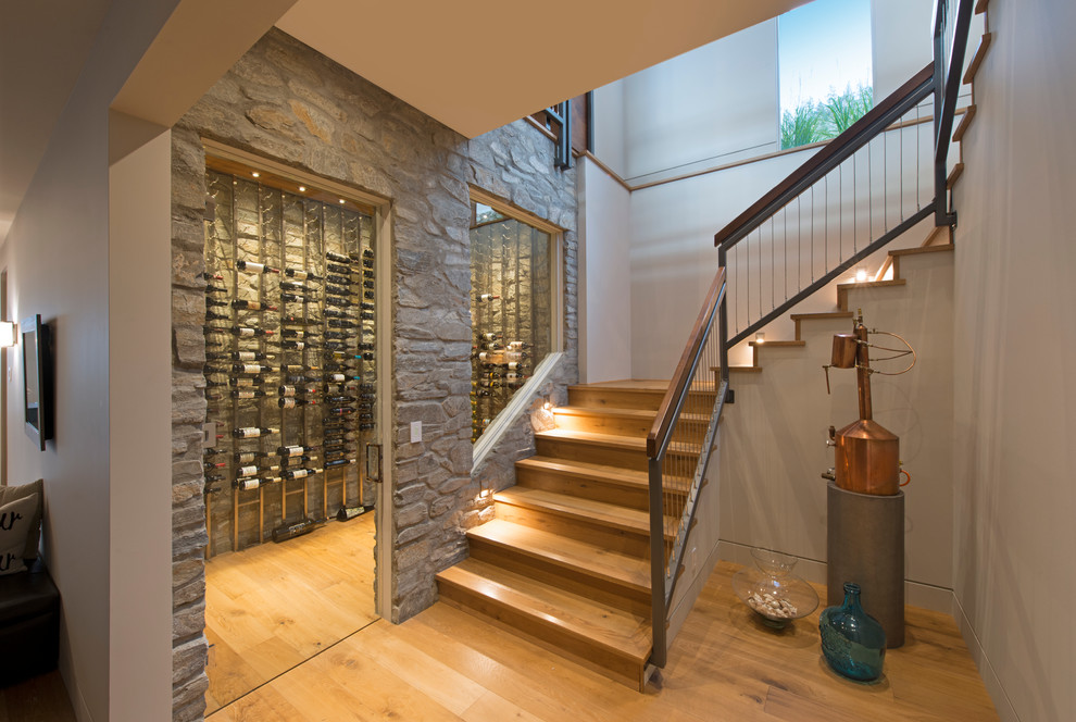 Wine cellar - contemporary medium tone wood floor wine cellar idea in Vancouver with display racks