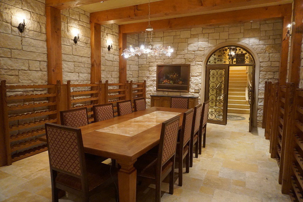 This is an example of an expansive mediterranean wine cellar in Orange County with limestone flooring and storage racks.