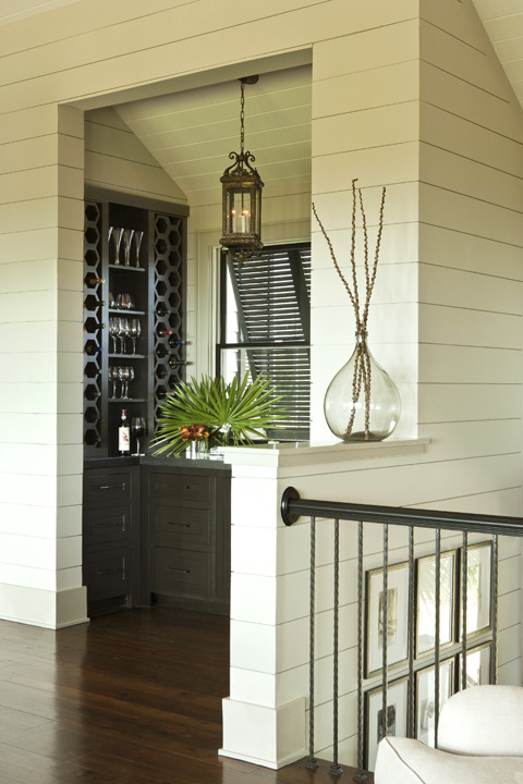Example of a mid-sized island style dark wood floor and brown floor wine cellar design in Charleston with storage racks