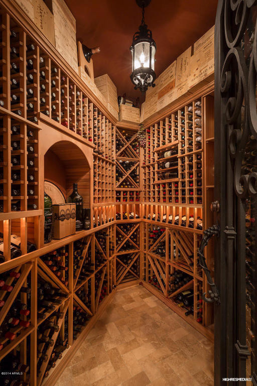 Idée de décoration pour une cave à vin tradition de taille moyenne avec un sol en travertin et des casiers.