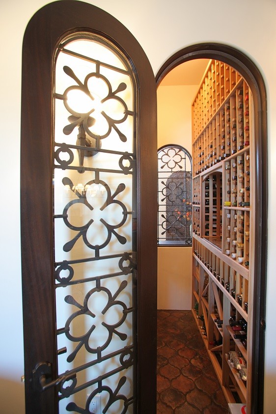 Exempel på en mellanstor vinkällare, med klinkergolv i terrakotta och vinhyllor