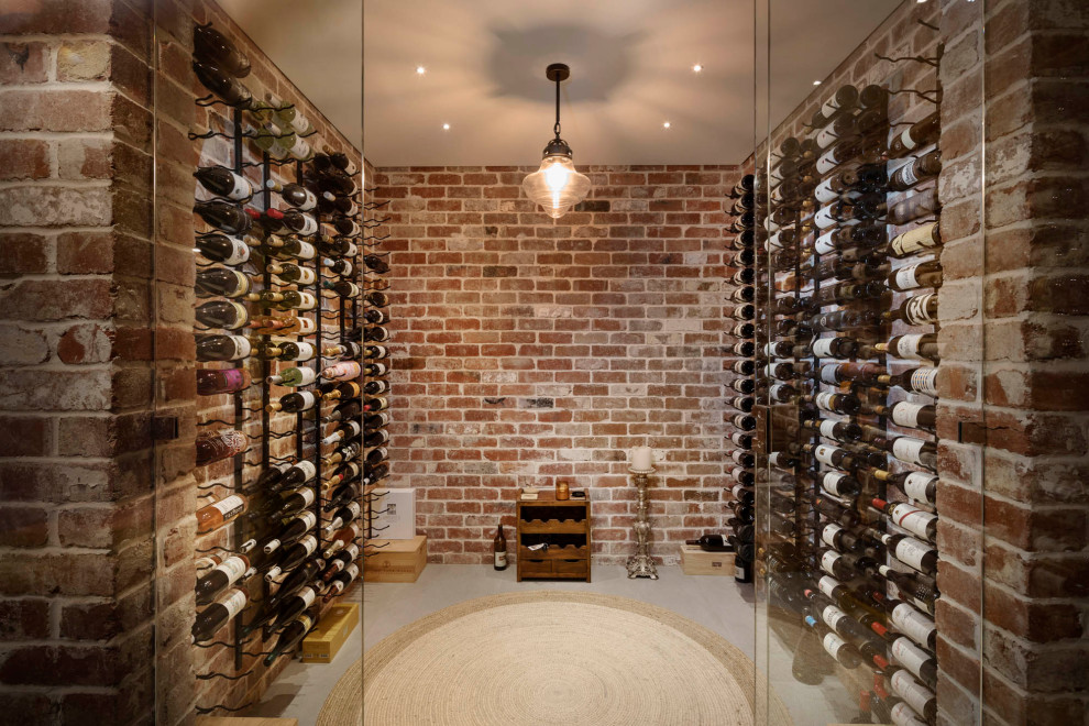 Photo of a traditional wine cellar in Perth with display racks and grey floors.