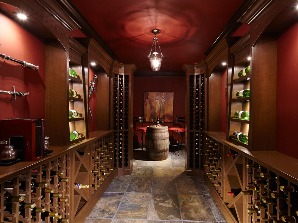 Cette image montre une cave à vin traditionnelle de taille moyenne avec un sol en ardoise, un présentoir et un sol multicolore.