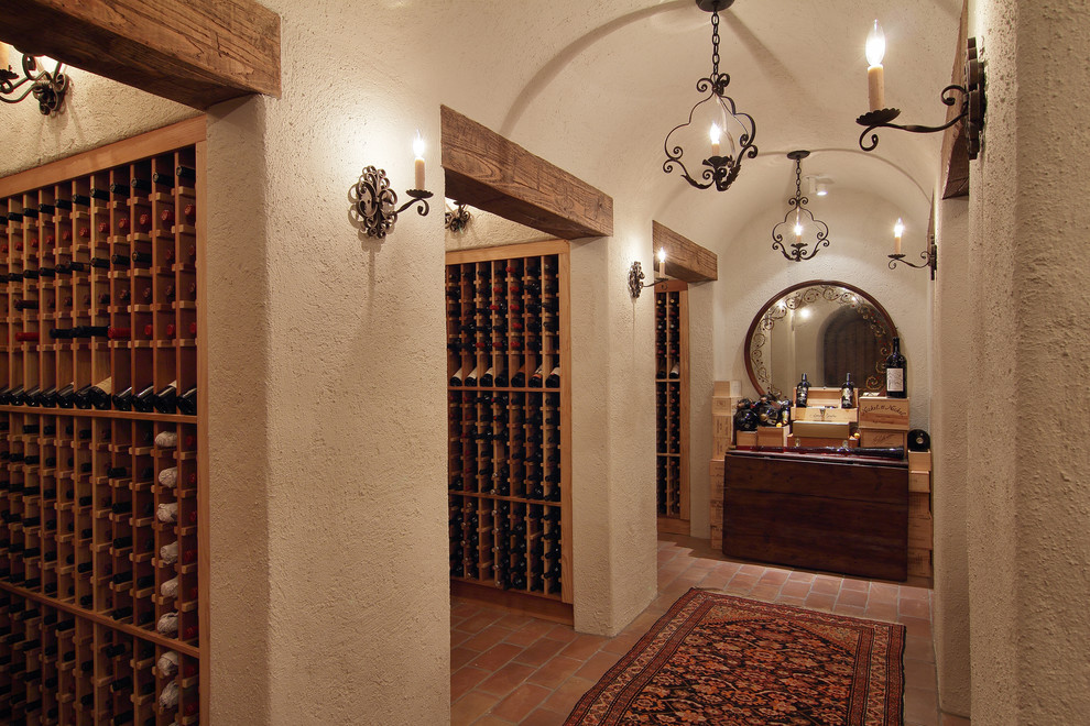 Photo of a large mediterranean wine cellar in Houston with terracotta flooring and storage racks.