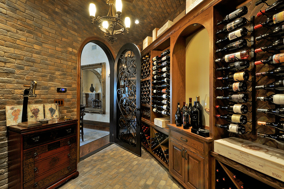 Cette image montre une très grande cave à vin traditionnelle avec un sol en brique et des casiers.