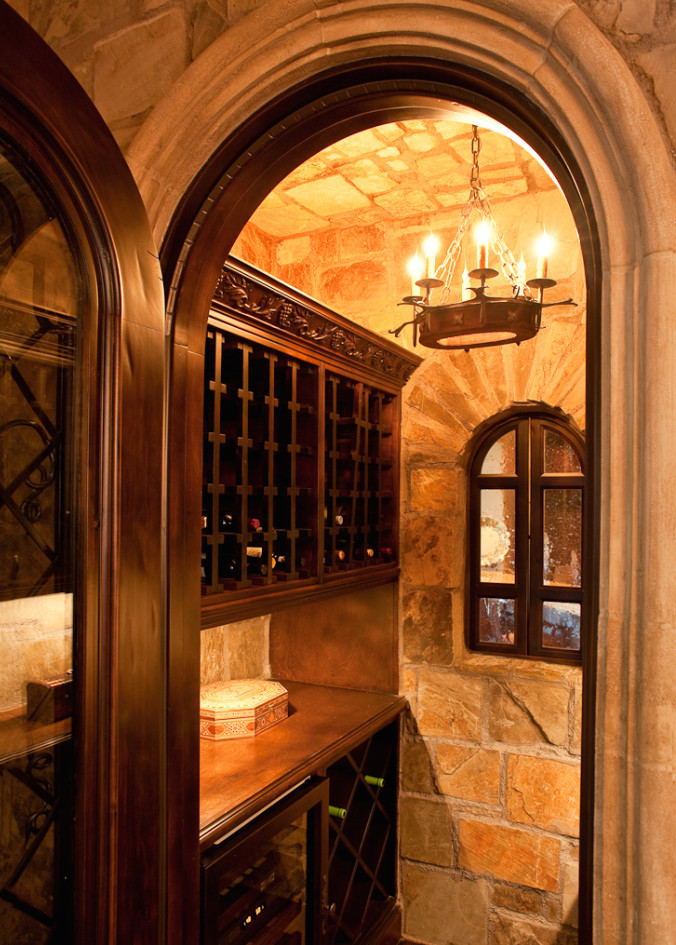 Expansive rustic wine cellar in Phoenix with dark hardwood flooring, storage racks and brown floors.