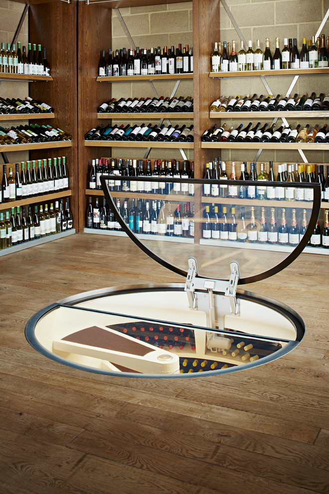 Inspiration pour une cave à vin design de taille moyenne avec des casiers et sol en béton ciré.