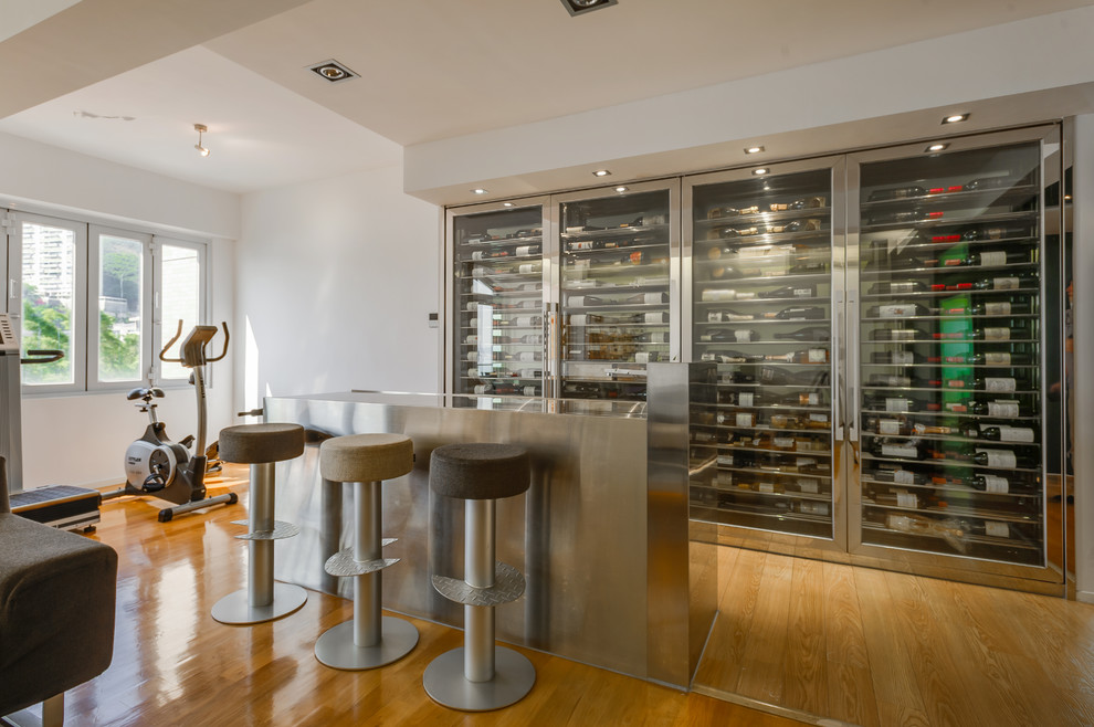 Inspiration for an industrial light wood floor and brown floor wine cellar remodel in Hong Kong with storage racks