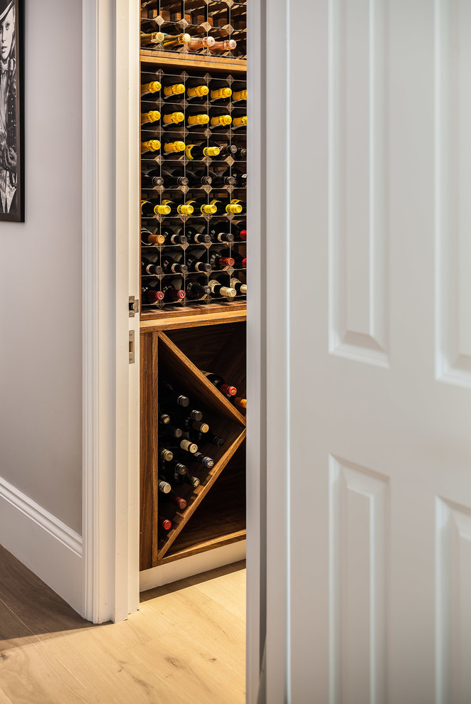 Inspiration for a small traditional wine cellar in London with medium hardwood flooring and display racks.