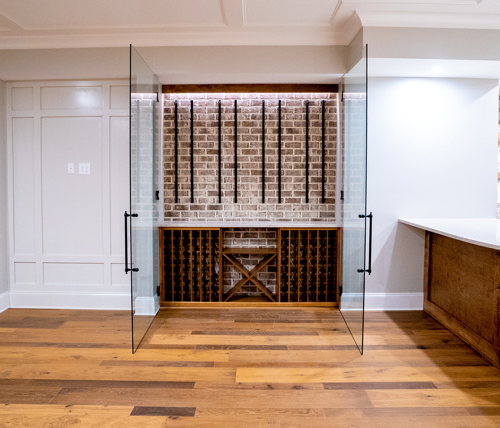 Example of a small trendy medium tone wood floor and brown floor wine cellar design in Atlanta with display racks