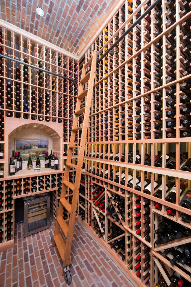Cette image montre une grande cave à vin traditionnelle avec un sol en brique et des casiers.