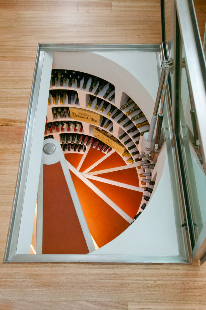 Example of a small trendy concrete floor wine cellar design in Sydney with display racks