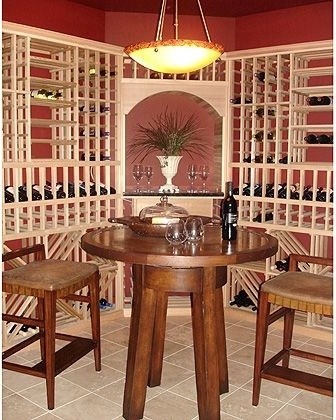 Cette photo montre une grande cave à vin chic avec un sol en carrelage de porcelaine, des casiers et un sol beige.