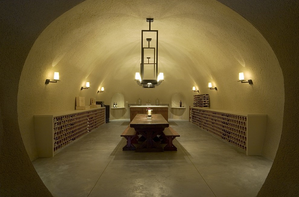 Idées déco pour une cave à vin contemporaine avec sol en béton ciré, des casiers et un sol gris.