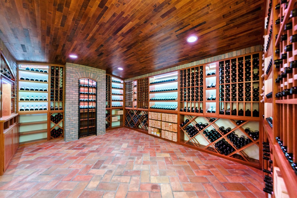 Inspiration för en mycket stor vintage vinkällare, med klinkergolv i terrakotta och vinhyllor