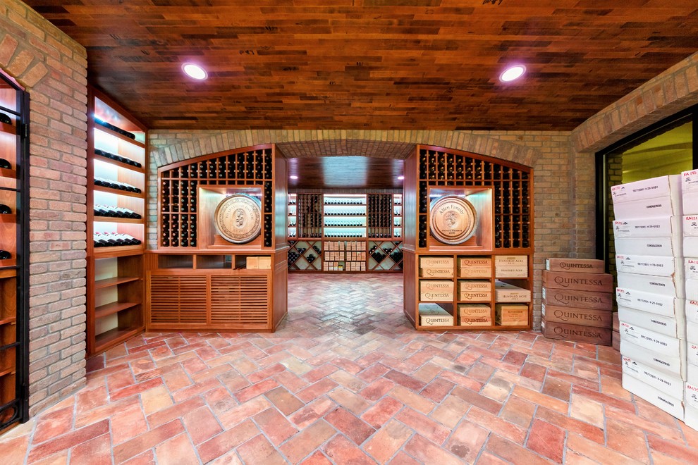 Wine cellar - huge traditional terra-cotta tile wine cellar idea in New York with storage racks