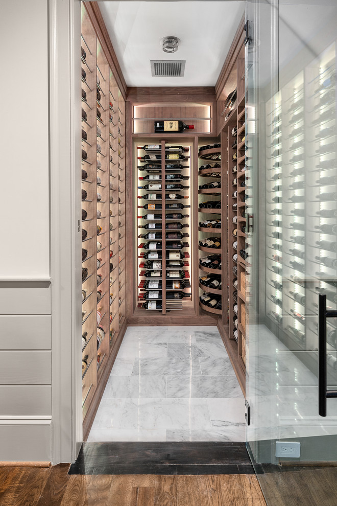 Cette photo montre une petite cave à vin chic avec un sol en marbre et des casiers.