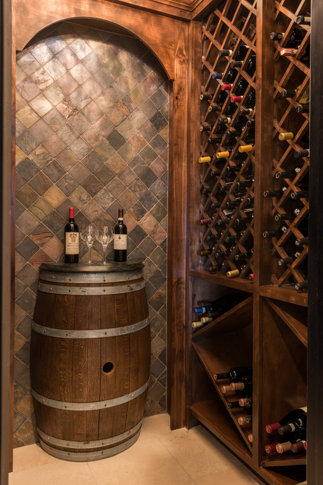 Mid-sized tuscan ceramic tile and beige floor wine cellar photo in Austin with storage racks
