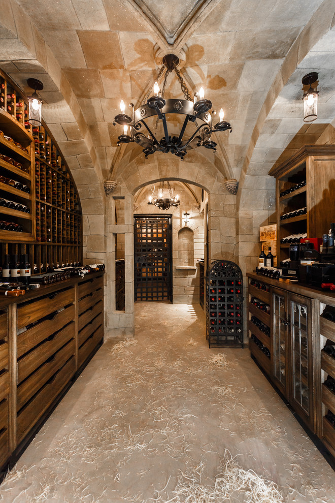Aménagement d'une très grande cave à vin classique avec un sol en brique et un présentoir.