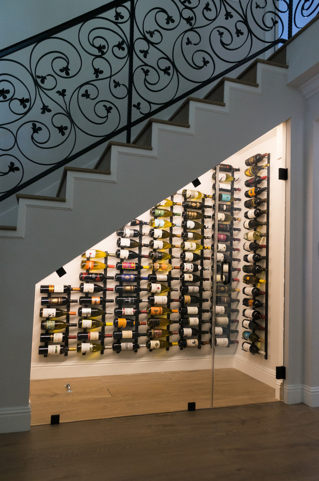 This is an example of a small classic wine cellar in San Francisco with laminate floors, storage racks and brown floors.