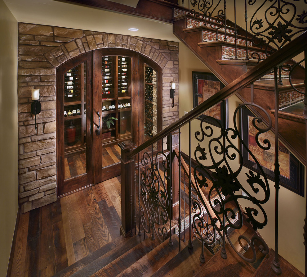 Inspiration for a mediterranean dark wood floor wine cellar remodel in Denver with display racks