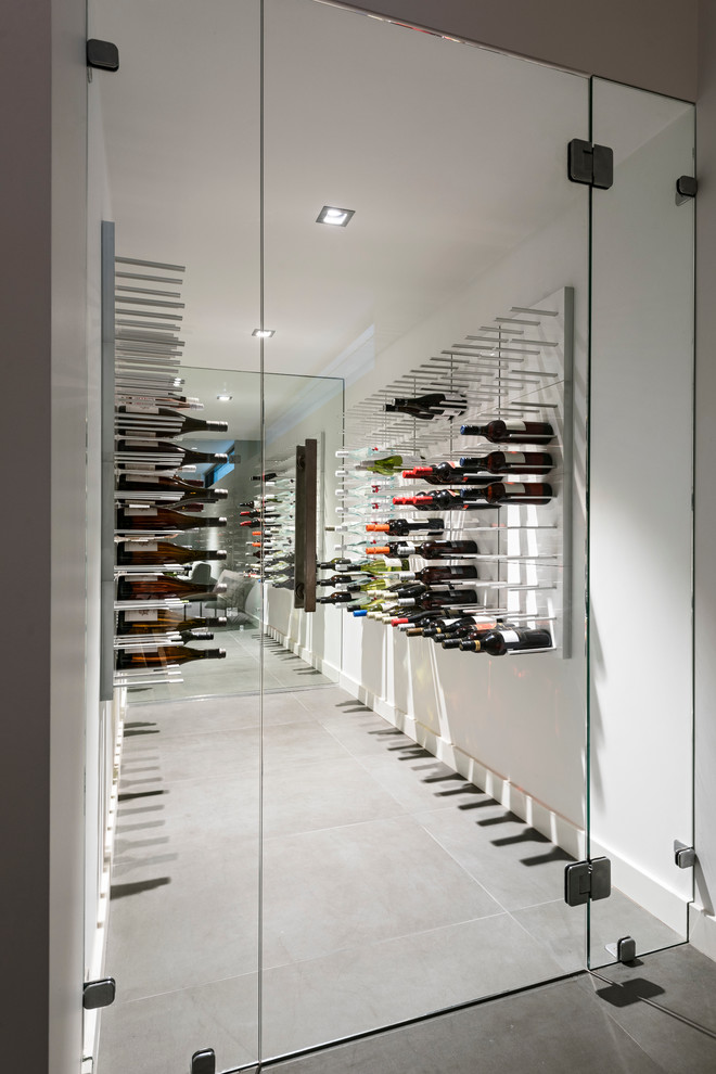 Idée de décoration pour une cave à vin design de taille moyenne avec un sol gris.