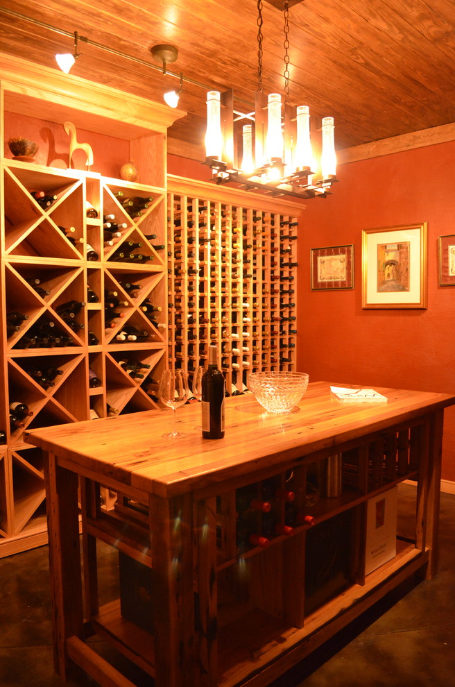 Exemple d'une grande cave à vin chic avec sol en béton ciré et des casiers.
