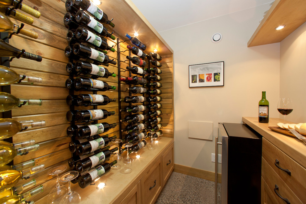 This is an example of a small traditional wine cellar in Vancouver with concrete flooring and storage racks.