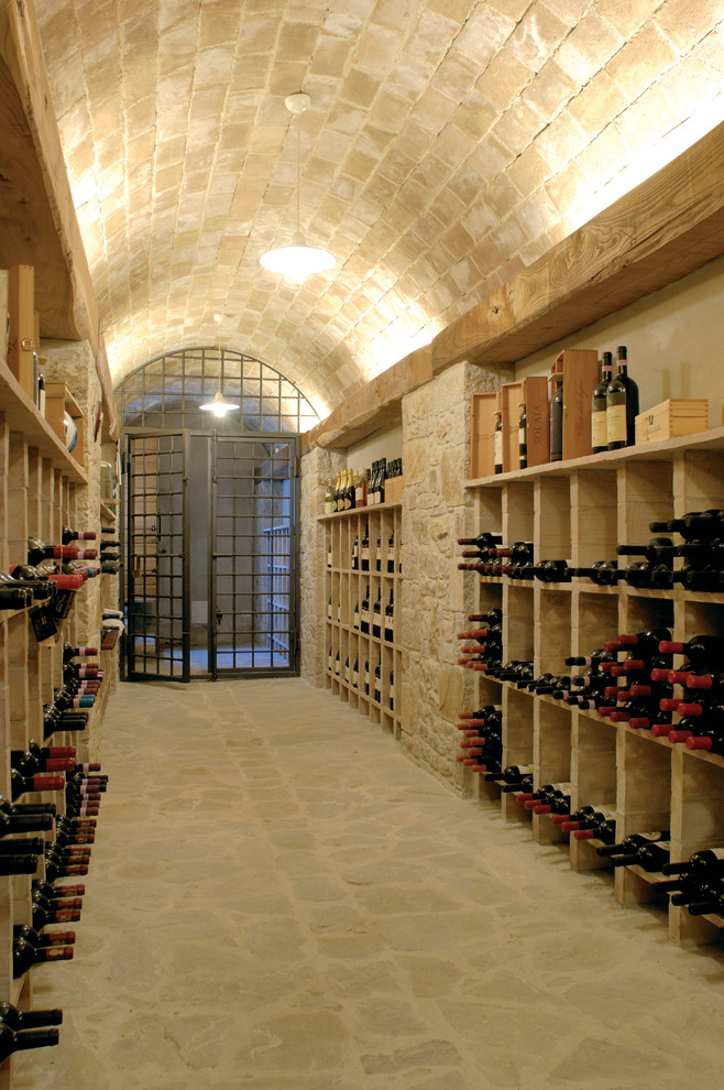 Cette image montre une très grande cave à vin rustique avec des casiers.