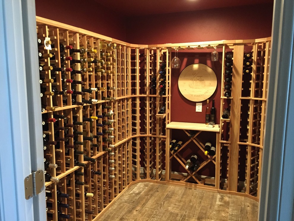 Idée de décoration pour une cave à vin tradition de taille moyenne avec un sol en bois brun et des casiers.