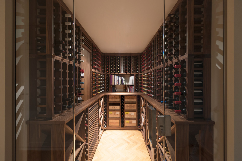 Großer Klassischer Weinkeller mit hellem Holzboden und Kammern in London